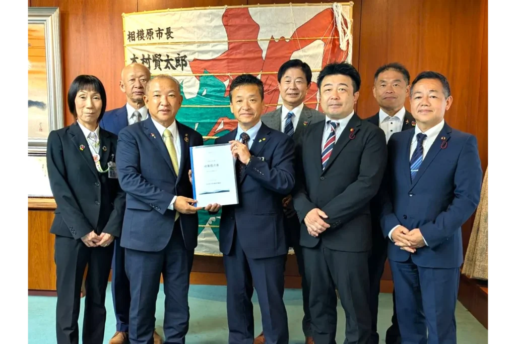 自由民主党相模原市議団の役員が本村賢太郎相模原市長に令和9年度政策提言書を手渡す様子
